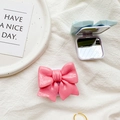 Foldable bow-shaped phone mirror stand in pastel colors on a textured cloth surface - Rose Red