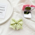 Macro view of 3D bow phone socket grip featuring a built-in makeup mirror in pink - Green