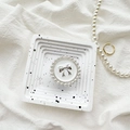 Close-up of pearl-rimmed circular phone grip with silver bow on white tray - Metal Bracket - Round Pearl Bow / White