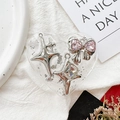 Dettaglio del supporto per telefono in resina a cuore con fiocco argento e strass rosa - Fiocco Meteora N.4