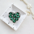 Detail view of heart-shaped green crystal phone socket with luxury diamond encrusted edges - Dark Green
