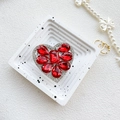 Dettaglio del supporto a cuore di lusso con cristalli rossi e bordo in strass argentati - Rosso