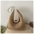 Detail der gewebten Strohtasche mit weißem Lederbesatz auf minimalistischem Holztisch - Weiß