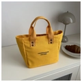 Vue détaillée du sac cabas en toile jaune avec lettrage noir et anses en tissu - Jaune