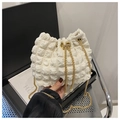 Detalle de bolso saco blanco con textura de burbujas, cadena dorada y adornos de perlas - Blanco