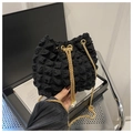 Detalle del bolso saco negro con textura de burbujas, cadena dorada y perlas - Negro