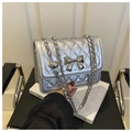 Details einer silbernen Stepptasche mit Metallschleife und Leder-Kettenschultergurt - Silber