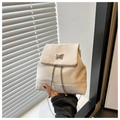 Close-up of cream suede mini backpack with silver butterfly buckle and chain strap - White
