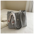 Détail du sac cabas plissé argenté avec poignée tressée et foulard en soie décoratif - Argenté