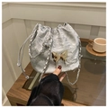 Borsa a secchiello argento con farfalla dorata e tracolla su tavolo in vetro - Argento