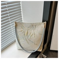 Detalle del bordado de hojas de bambú y hilos dorados en un bolso de hombro elegante - Hoja de Bambú
