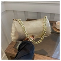 Dettaglio di una borsa sottobraccio dorata con una spessa tracolla a catena per donna - Oro