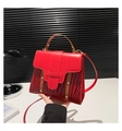 Detail of red crocodile texture and smooth leather contrast on a stylish handbag - Red
