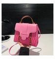 Vue détaillée de la texture crocodile rose et des rivets dorés sur un sac à main - Rose