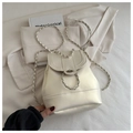 Detalle de bolso bandolera blanco crema con correa de cadena plateada y cierre giratorio - Beige