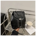 Detailansicht eines schwarzen Kunstlederrucksacks mit Silberkette und Drehverschluss - Schwarz