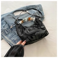 Dettaglio di una borsa a mezzaluna con manico in perline acriliche e texture marmo - Nero