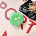 Nahaufnahme der grünen Marmor-Handyhalterung mit Love-Schriftzug auf rosa Hintergrund - Marmorgrün (Love)