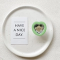 Detail view of heart-shaped phone grip with faceted crystal inlay on a minimalist tray - Transparent Stand - Green Frame White Crystal