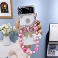 Detailed shot of Z Flip 6 clear case with pink rhinestones, crystal bow and beaded strap - Pink / Samsung ZFlip3