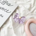 Detail of a purple butterfly phone grip stand with translucent resin finish on soft fabric - Purple Bow