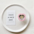 Macro view of a pink heart-shaped phone grip with a faceted crystal center on a ceramic plate - Transparent Stand - Pink Frame White Crystal