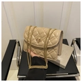 Detailed view of the diamond quilted texture and golden twist lock on the beige bag - Khaki
