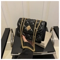 Detail of black quilted leather handbag featuring gold metal chain and diamond lock - Black