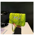 Detail of neon green quilted crossbody bag with silver bow and ball pendant chain - Green