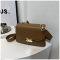 Detailed shot of a vintage brown square bag with a golden metal lock and wide strap - Khaki
