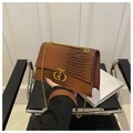 Dettaglio borsa a tracolla marrone goffrata coccodrillo con catena d'oro e chiusura CD in metallo - Marrone