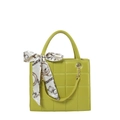 Green quilted handbag with silk scarf decoration and gold hardware on white background - Green