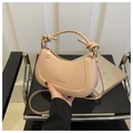 Detail der beigen halbmondförmigen Schultertasche mit Knotengriff und Schultergurt - Rosa