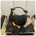 Detailansicht der schwarzen Halbmondtasche mit Knotengriff und Gold-Hardware - Schwarz
