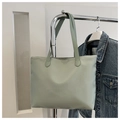 Detalle de bolso tote de nailon verde menta colgado con fondo de chaqueta vaquera - Verde