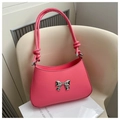 Detail of pink handbag featuring a silver bow accent and unique knotted leather handle - Pink