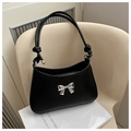 Detail of black crossbody bag featuring a silver metal bow and knotted handle design - Black