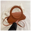 Detail of a brown geometric leather handbag with a round handle and adjustable strap - Tan
