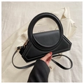 Bolso bandolera geométrico negro con asa redonda y herrajes dorados sobre blazer beige - Negro