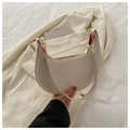 Close-up of cream crescent bag featuring gold zipper hardware and vibrant red interior lining - White