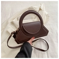 Detail of deep brown geometric crossbody bag with a round handle and gold hardware - Coffee