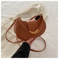 Close-up of brown leather crescent bag with elegant gold metallic crescent buckle - Tan