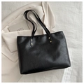 Detail of vintage leather tote bag showing golden rivet reinforcement on shoulder straps - Black