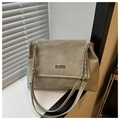 Detalle del bolso tote beige claro con placa de logo plateada y correa de cadena - Gris claro
