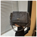 Vista dettagliata della borsa a patta grigio scuro testurizzata con logo in metallo e catena - grigio scuro