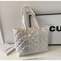 Detail shot of the glossy quilted fabric and rhombic stitching on this cream puffer tote bag - Off White