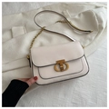 Détail du sac selle crème avec fermoir en métal doré vintage et bandoulière en chaîne - Blanc