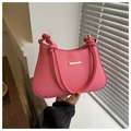 Close-up of bright pink leather handbag featuring a gold buckle and knotted shoulder strap - Pink