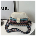 Detailed macro of ethnic embroidery and gold hardware on canvas crossbody bag - Blue
