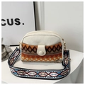 Close-up of geometric woven pattern and colorful embroidery strap on canvas bag - Orange